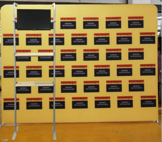 A shelving unit with a yellow background and a screen attached, featuring dark panels without visible text.