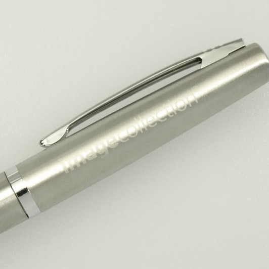 A silver pen with a sleek design and a clip, featuring subtle branding.