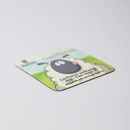 A square fridge magnet with rounded corners featuring a cartoon sheep design in green and white colours, with a logo.