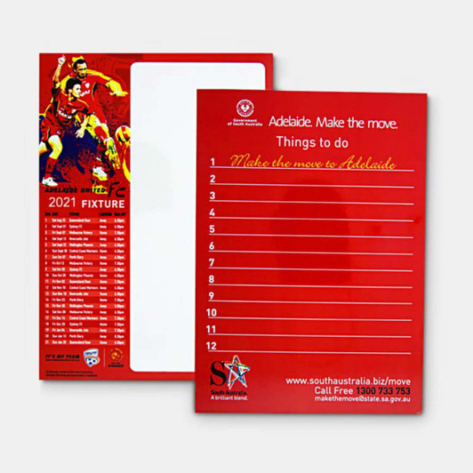 A red magnetic whiteboard featuring a blank writing surface and a list template on one side, with a logo.