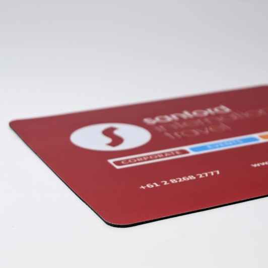 A red mouse mat with a logo and contact details in white and blue. Dimensions are 230mm x 190mm.