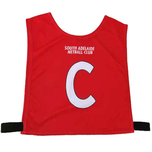 Red pull-over netball bib featuring a white letter "C" and a logo for South Adelaide Netball Club.
