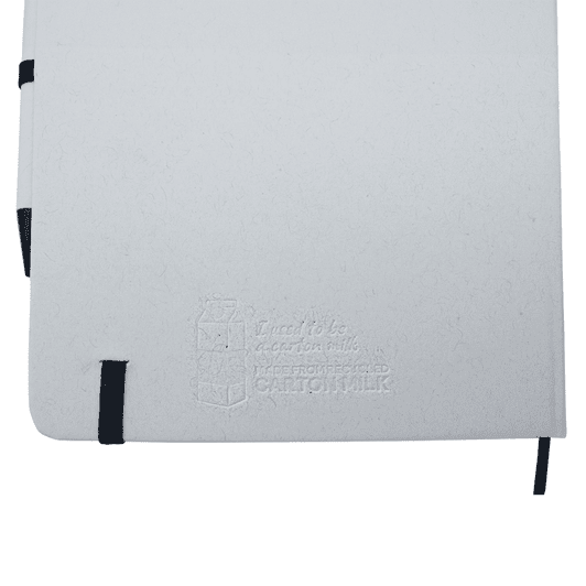 A white A5 notebook with a black elastic band and a black pen, featuring a subtle embossed logo.