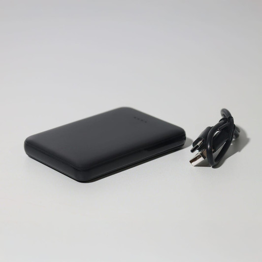A black 5000mAh powerbank alongside a charging cable. The powerbank has a sleek, rectangular design.