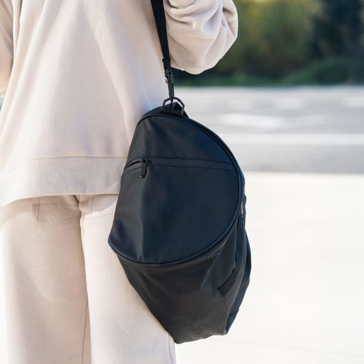 A black duffle bag with a sleek design featuring a shoulder strap and a zip pocket.