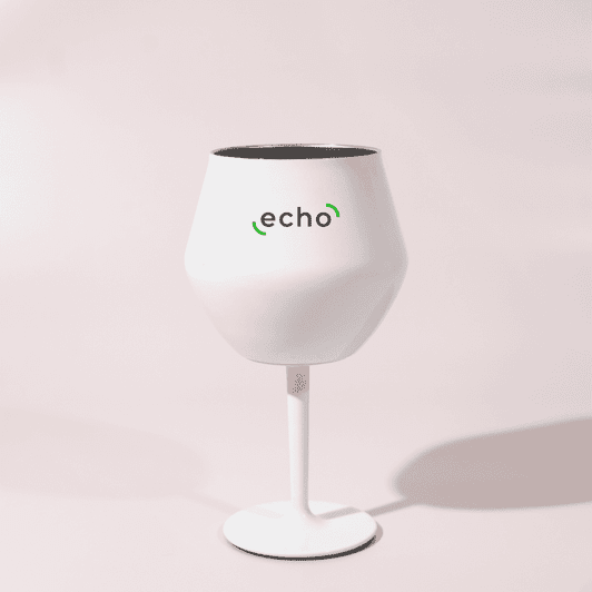A white Shiraz detachable wine glass with a black interior and a stand, featuring a logo.