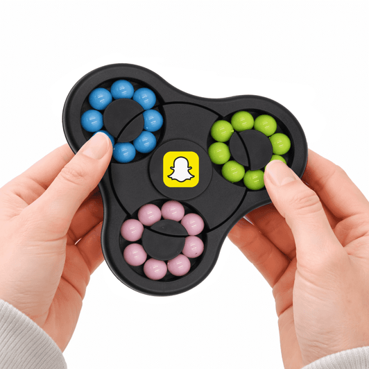 A hands holding a black puzzle game featuring blue, green, pink, and yellow components with a logo in the centre.
