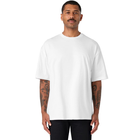 A white oversized tee is worn by a man with tattoos, featuring a simple design and a comfortable fit.