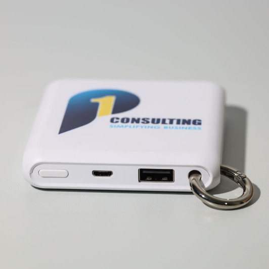A white power bank with a keyring attachment, featuring USB and micro USB ports and a logo.