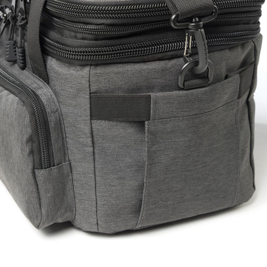 A grey cooler bag with multiple zippered compartments and pockets, featuring a logo on the side.