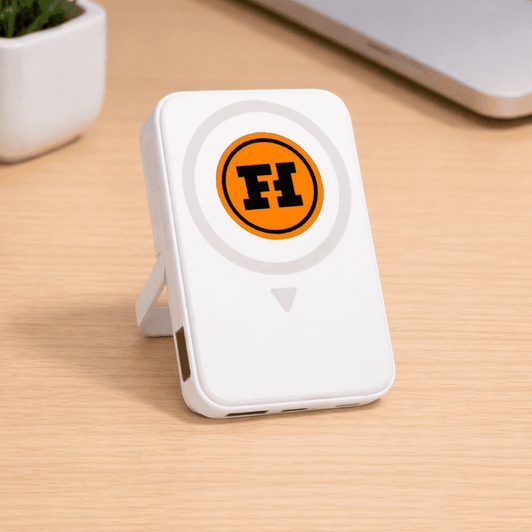 A white wireless charging powerbank with a logo, featuring a built-in stand and two USB ports.