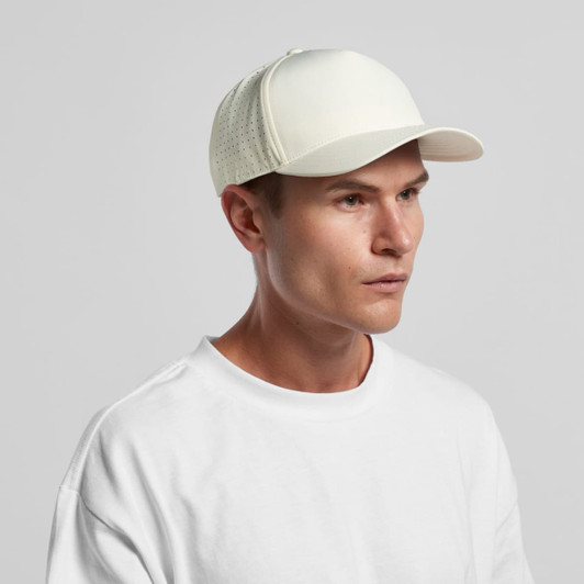 A white perforated cap featuring a structured front. The cap has a logo and is paired with a plain white T-shirt.
