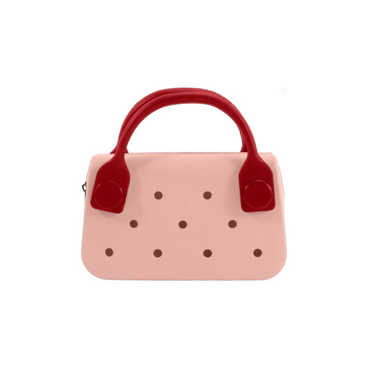 A pink mini handbag with red handles featuring circular holes along the front. It has a simple, stylish design.