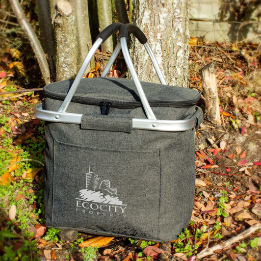 A grey cooler basket with a silver frame and handle, featuring a logo on the front.