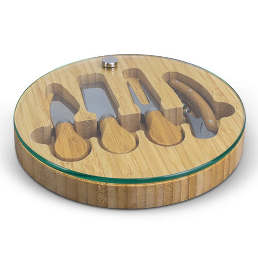 A bamboo cheese board with a glass top, featuring four cheese knives and a recessed area for serving.
