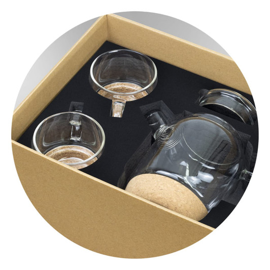 A tea set featuring a clear glass teapot with cork base and two matching glass cups, presented in a brown cardboard box.