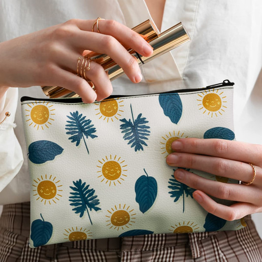 A medium cosmetic bag featuring a nature-inspired design with leaves and suns in blue and yellow on a white background.