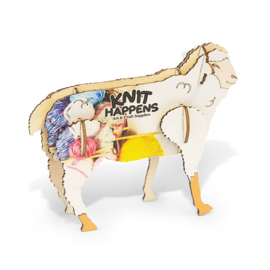 A wooden model of a sheep with colourful yarn decorations, featuring a logo on its side.