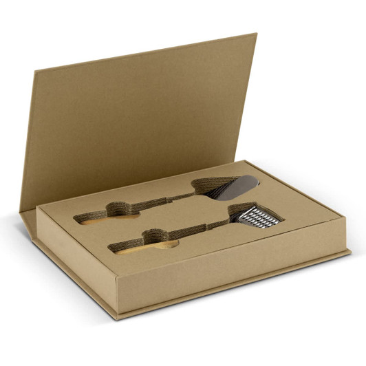 A kitchen slicer and grater set in a brown cardboard box, featuring metallic tools and a branded logo.