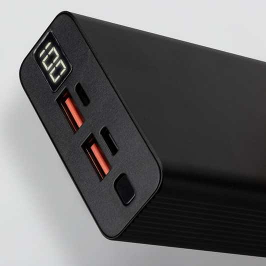 A black power bank with two USB ports, one USB-C port, and a digital display showing battery percentage.