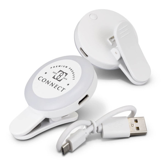 A white selfie light with a clip and USB charging cable, designed for mobile phones. It features a branded logo.