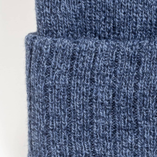 A blue knitted beanie with a folded cuff, showcasing a textured pattern. It features a branding logo.