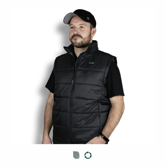 A man wearing a black puffer vest, featuring a zip closure and high collar, with a logo on the chest.