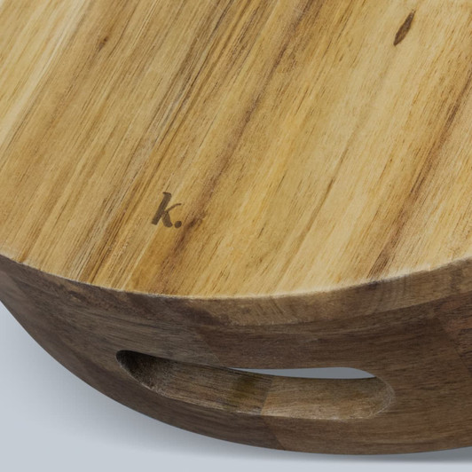 A wooden platter tray with a smooth surface and a carved handle, featuring a subtle branding mark.