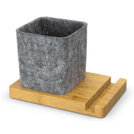 A grey felt phone stand desk caddy sits on a wooden bamboo base. The design is simple and modern.