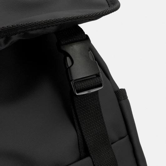 A close-up of a black soft-touch backpack featuring a clip and adjustable strap. The material appears durable.