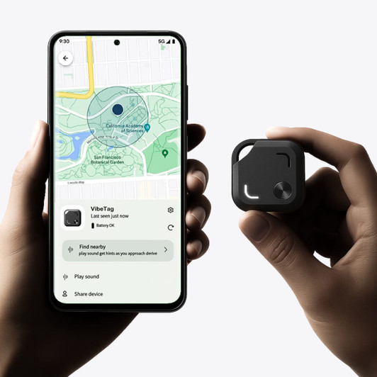 A hand holds a small black Bluetooth tracker next to a smartphone displaying a map and tracking interface.