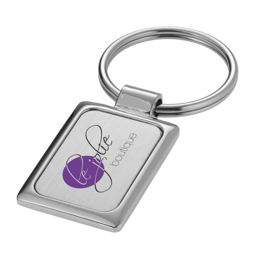 A rectangular silver keyring featuring a logo, with a polished finish and a circular attachment loop.