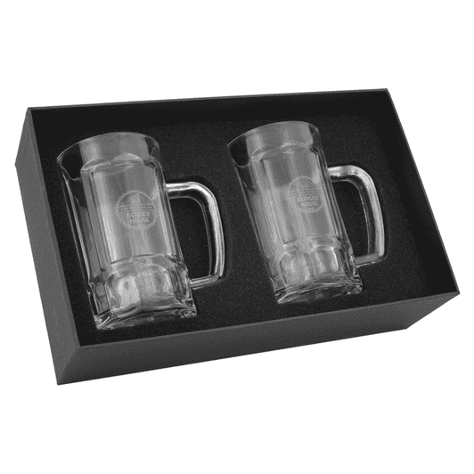 A set of two clear glass Bavarian beer mugs, packaged in a black gift box, featuring a logo.
