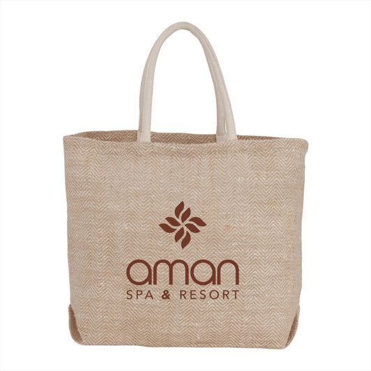 A beige herringbone jute tote bag with contrasting handles and a logo on the front.