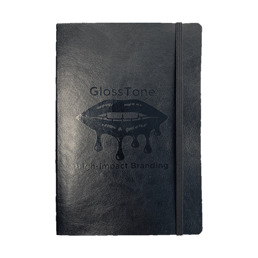 A black soft bound journal with an elastic closure and a logo printed on the cover.