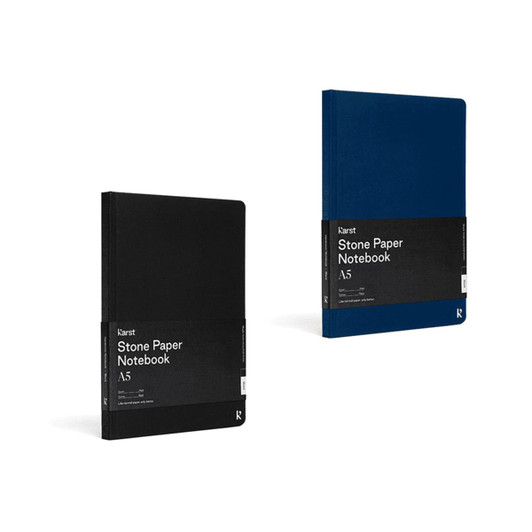 Two hardcover A5 notebooks in black and navy blue, featuring branding and a stone paper design.