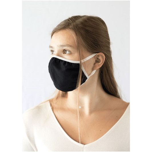 A black face mask with white ear straps, worn by a model with long hair, against a plain background.