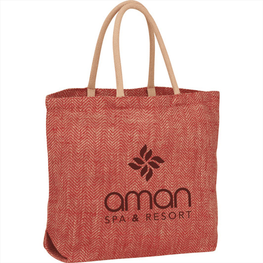 A red herringbone jute tote bag with light brown handles and a logo on the front.