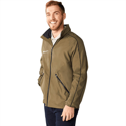 A man wearing an olive green packable jacket with a zippered front and side pockets, featuring a logo.
