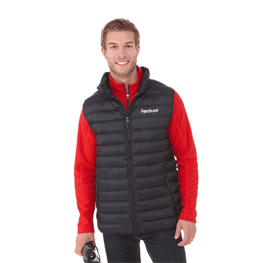A man wearing a black insulated vest over a red long-sleeve shirt, holding a drink bottle. The vest has a logo.