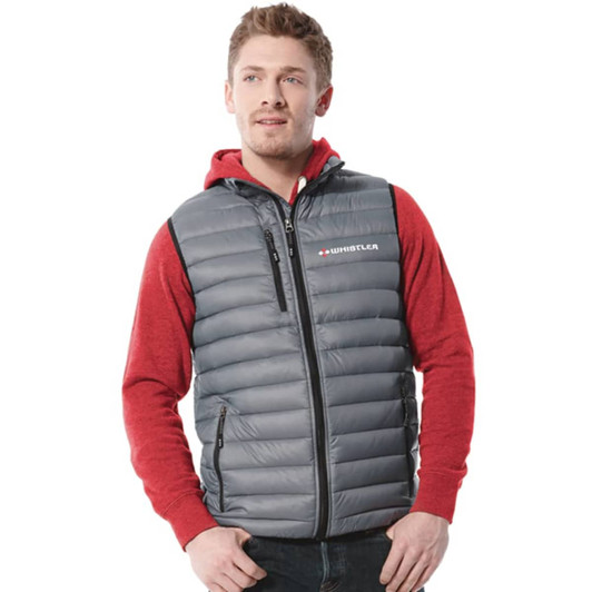 A man wearing a grey puffer vest over a red hoodie. The vest features a logo and is zippered.