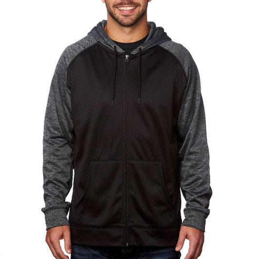 A man is wearing a black full zip performance raglan hoodie with grey sleeves and a front pocket. The hoodie has a logo.