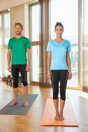 A green men's T-shirt and a light blue women's T-shirt, both paired with black activewear bottoms, in a bright room.