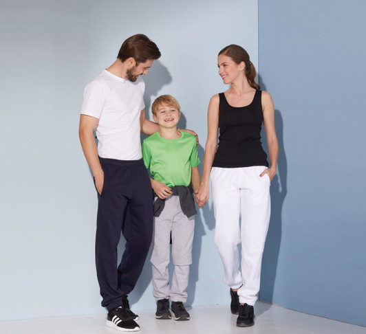 Men's jogging pants in navy, paired with a boy in grey bottoms and a girl in white pants, with a black and green top.