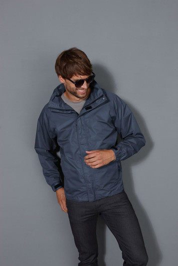 A men's outer jacket in navy, featuring a hood, worn by a model with sunglasses, set against a grey background.