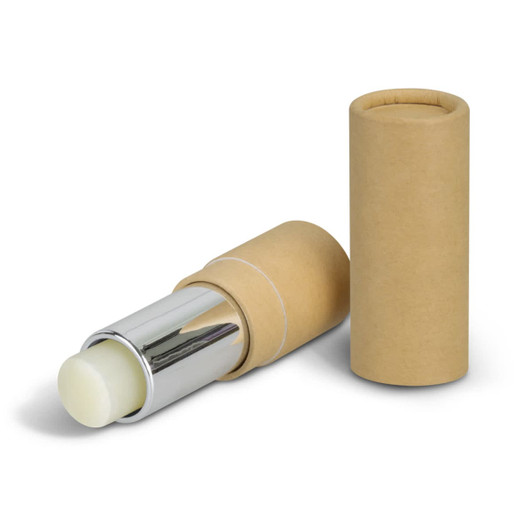 A lip balm in a silver and natural cardboard tube, with the tube's cap beside it. The balm appears to be a light colour.