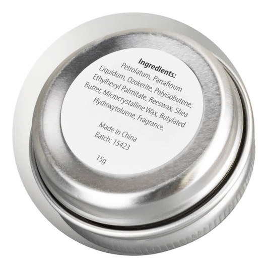 A silver lip balm tin with a round shape, showing a label with ingredient details on the top.