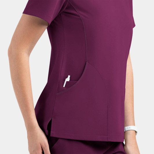 A women's contrast v-neck top in burgundy with a side pocket, featuring a subtle logo.