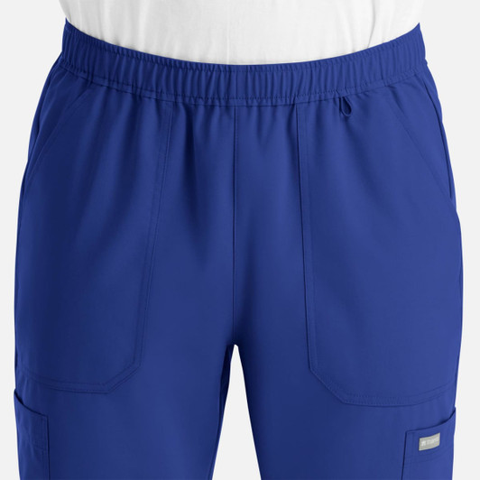 A pair of blue jogger pants with an elastic waistband and pockets. The pants feature a logo.