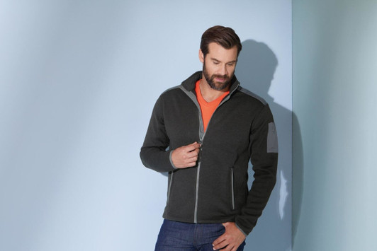 A men's knitted fleece jacket in dark grey with a contrasting collar, featuring a logo on the left sleeve.